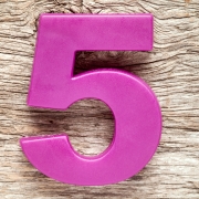 Purple number five on the wooden background