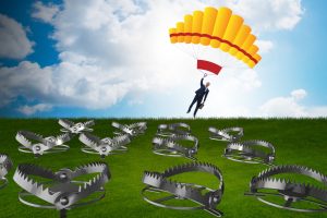 Businessman falling into trap on parachute