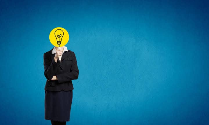 Unrecognizable businesswoman hiding her face behind mask